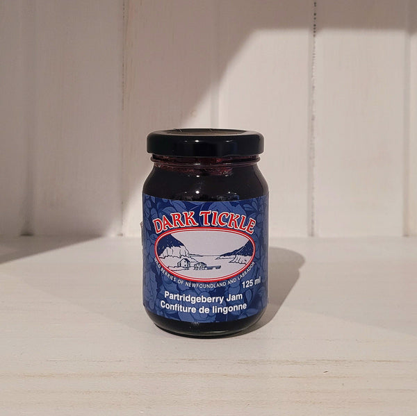 125ml jar of Dark Tickle partridgeberry jam on a wooden surface