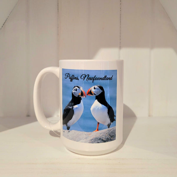 White mug with a photo of puffins in Newfoundland on it on a white background
