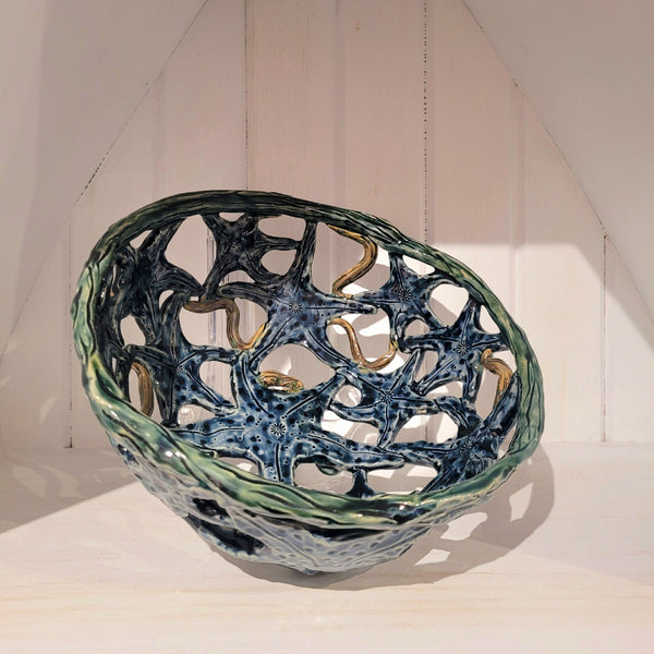 Decorative ceramic starfish bowl with textured surface on a white background