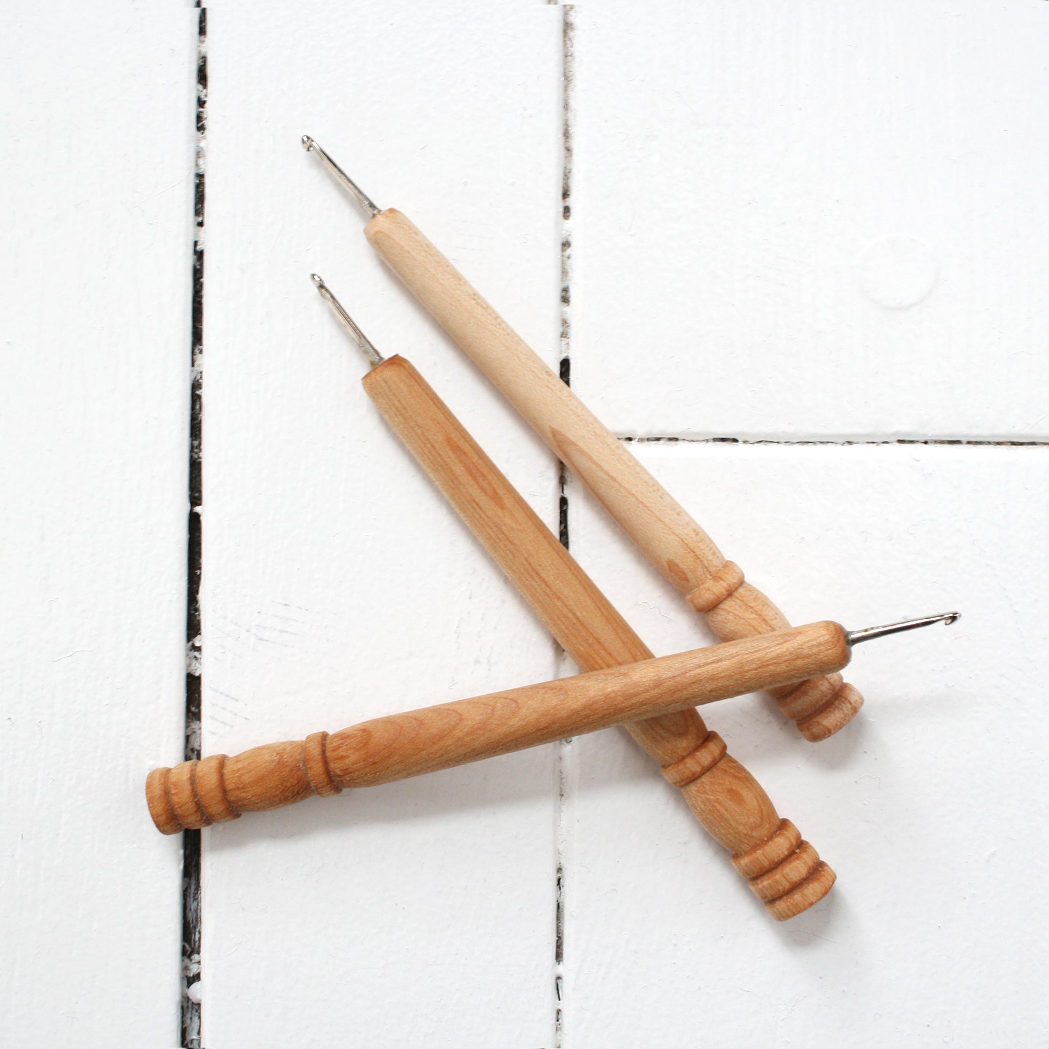 three Molly Made rug hooks with wooden handles