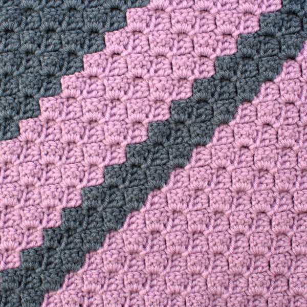 close up of a two-toned purple crochet blanket showing texture and pattern
