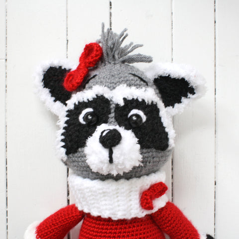 Crocheted raccoon plush toy with red dress and bow made in Newfoundland
