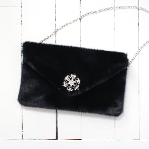 black sealskin clutch with decorative clasp and chain strap